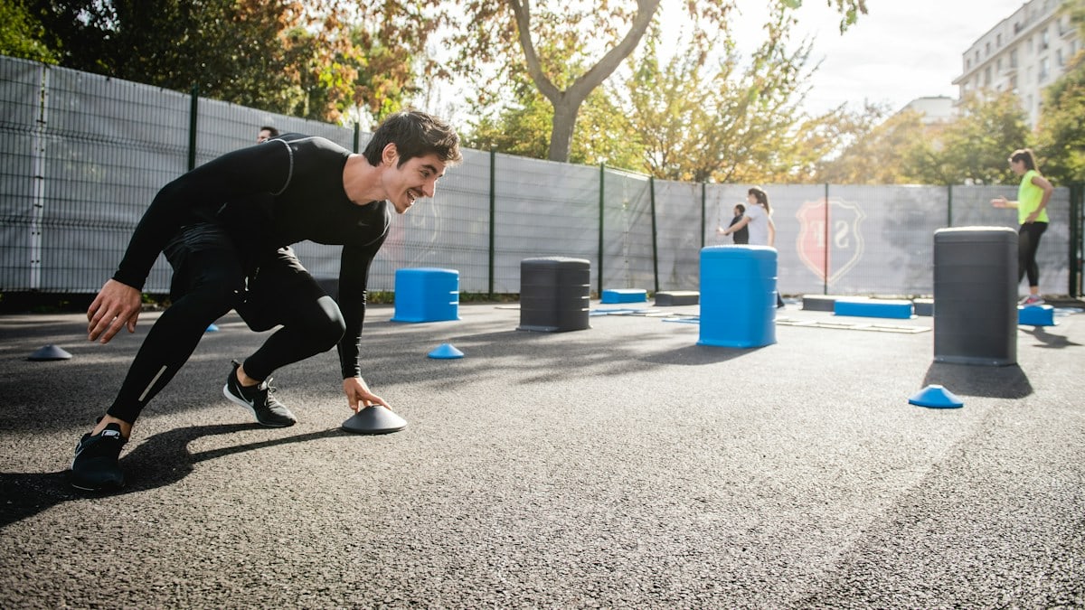 boy in black long sleeve shirt and blue pants playing with blue plastic container during daytime
